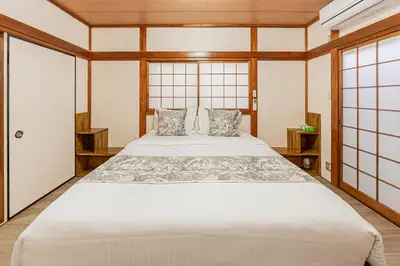 a bedroom with a large white bed and windows at Family House \u857e \u6c60\u888b\u5f92\u6b65\u5708\u5168\u65b0\u88c5\u4fee\u65e5\u5f0f\u6237\u5efa\u6c11\u5bbf in Tokyo
