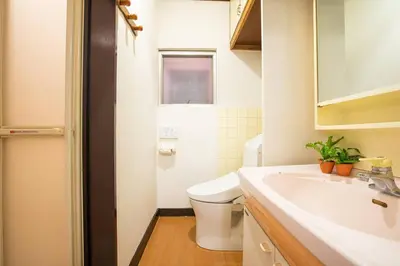 a white bathroom with a toilet and a sink at \u6cca\u9732Hakuro 3\u968e in Tokyo