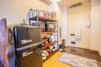 a kitchen with a refrigerator and a shelf with a microwave at Comptoir Shinjuku 411 - Vacation STAY 17791 in Tokyo