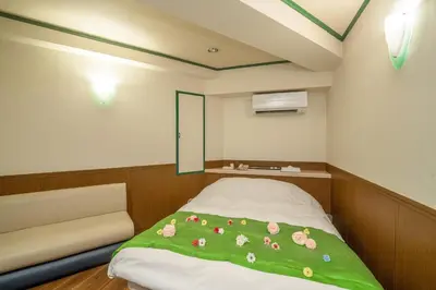 a small room with a bed with flowers on it at Hotel SUNROAD Adult Only in Tokyo