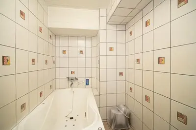 a white tub in a bathroom with white tiles at Hotel SUNROAD Adult Only in Tokyo