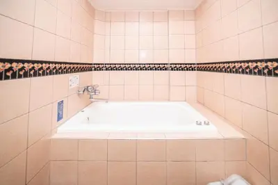 a bathroom with a bath tub in a tiled bathroom at Hotel SUNROAD Adult Only in Tokyo