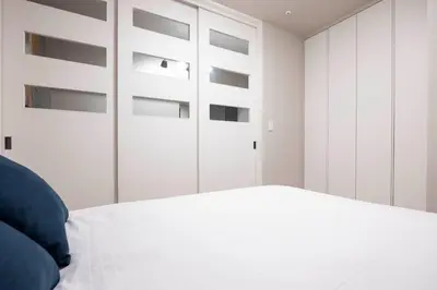 a bedroom with white cabinets and a bed at MAT Ryogoku in Tokyo
