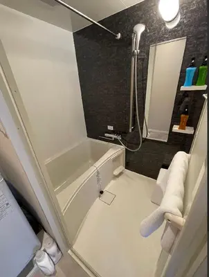 a small bathroom with a tub and a shower at Solana Roppongi in Tokyo