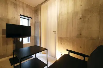 a living room with a table and a tv on a wall at AirHOME TOKYO EBISU101 in Tokyo