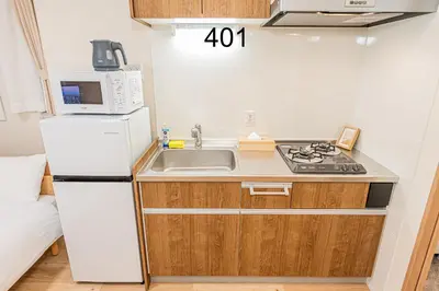 a small kitchen with a white refrigerator and a sink at Newly build Family-APT , Shinjuku Shibuya Ueno in 15 minutes by train in Tokyo