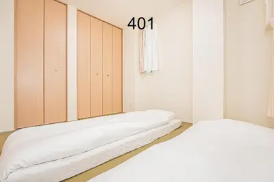 a room with two beds and a cabinet with the number at Newly build Family-APT , Shinjuku Shibuya Ueno in 15 minutes by train in Tokyo