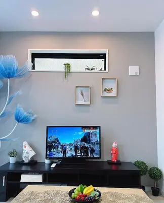 a living room with a flat screen tv on a wall at \u6771\u4eac\u30b9\u30ab\u30a4\u30c4\u30ea\u30fc\u30cf\u30a6\u30b9JoY in Tokyo