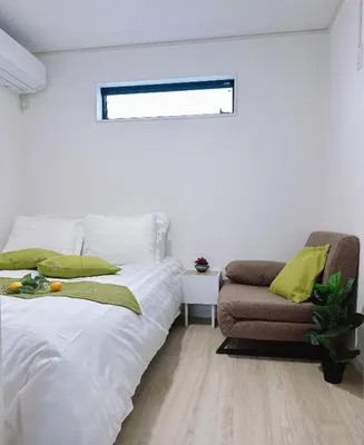 a white bedroom with a bed and a couch at \u6771\u4eac\u30b9\u30ab\u30a4\u30c4\u30ea\u30fc\u30cf\u30a6\u30b9JoY in Tokyo