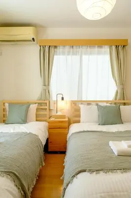 a bedroom with two beds and a window at Beyond Comfort \u65b0\u5bbf\u5927\u4e45\u4fdd - \u6700\u592710\u540d\u3067\u3086\u3063\u305f\u308a\u6ede\u5728 in Tokyo