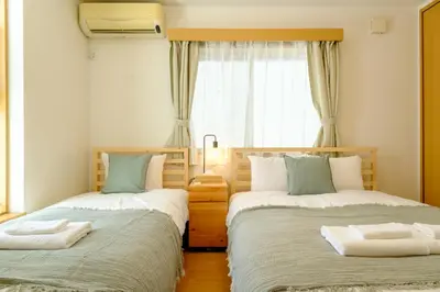 a bedroom with two beds and a window at Beyond Comfort \u65b0\u5bbf\u5927\u4e45\u4fdd - \u6700\u592710\u540d\u3067\u3086\u3063\u305f\u308a\u6ede\u5728 in Tokyo