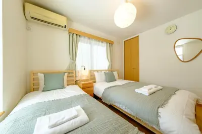 a bedroom with two beds and a mirror at Beyond Comfort \u65b0\u5bbf\u5927\u4e45\u4fdd - \u6700\u592710\u540d\u3067\u3086\u3063\u305f\u308a\u6ede\u5728 in Tokyo