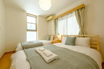 a bedroom with two beds and a large window at Beyond Comfort \u65b0\u5bbf\u5927\u4e45\u4fdd - \u6700\u592710\u540d\u3067\u3086\u3063\u305f\u308a\u6ede\u5728 in Tokyo