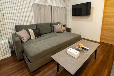 a living room with a couch and a table at 98, Higashi-tateishi A 1st floor of the apartment, \u6771\u7acb\u77f3A 1F in Tokyo