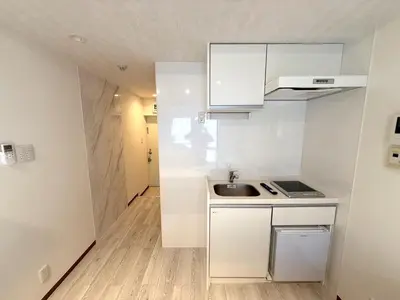 a small kitchen with white cabinets and a sink at NEW fukuhana\u6771\u65b0\u5bbf in Tokyo