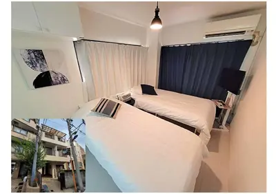 two beds in a small room with a window at HUJI Shinjuku House in Tokyo