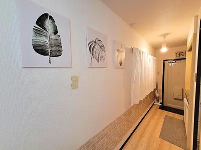 a hallway with pictures of butterflies on the walls at HUJI Shinjuku House in Tokyo