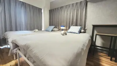 two beds with stuffed animals sitting on them in a bedroom at HUJI Shinjuku House in Tokyo