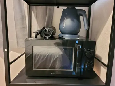 a microwave with a coffee pot on top of it at HUJI Shinjuku House in Tokyo