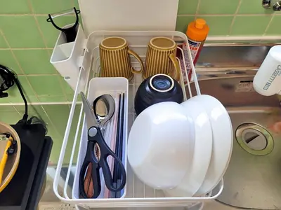 a shelf with plates and utensils in a kitchen at Liberty Shinjuku House in Tokyo