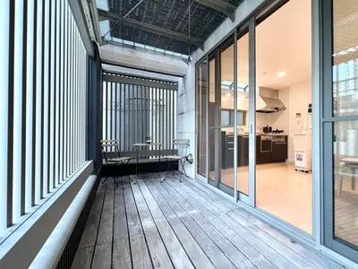 a large room with a wooden floor and windows at R-Akabane House-KI0319 in Tokyo