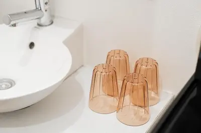 three wooden slippers sitting on a bathroom counter next to a sink at Shinjuku luxury Apart ment 2 minutes from Higashi-Shinjuku in Tokyo