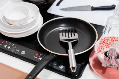 a frying pan with a spatula on top of a stove at Shinjuku luxury Apart ment 2 minutes from Higashi-Shinjuku in Tokyo