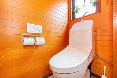 a bathroom with a white toilet in a wooden wall at ZSF-Kameido House -KT0413 in Tokyo