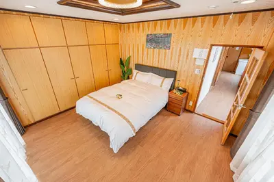 a bedroom with a bed in a room with wooden walls at ZSF-Kameido House -KT0413 in Tokyo