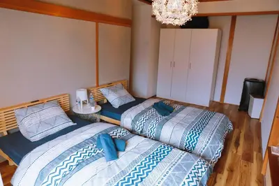 two beds sitting next to each other in a room at \u4e00\u68df\u8cb8\u3057\u5e83\u3005115\u5e73\u7c73 \u8cb4\u9802\u5e9c\u90b8 \u5927\u8c37\u7530 KICYO HOUSE No1 in Tokyo