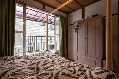 a bedroom with a bed and a large window at \u4e00\u68df\u8cb8\u3057\u5e83\u3005115\u5e73\u7c73 \u8cb4\u9802\u5e9c\u90b8 \u5927\u8c37\u7530 KICYO HOUSE No1 in Tokyo
