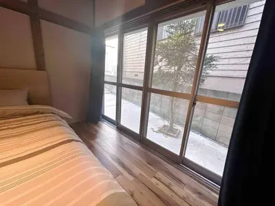 a bedroom with a bed and a large window at \u4e00\u68df\u8cb8\u3057\u5e83\u3005115\u5e73\u7c73 \u8cb4\u9802\u5e9c\u90b8 \u5927\u8c37\u7530 KICYO HOUSE No1 in Tokyo
