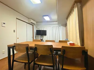 a dining room with a wooden table and chairs at Ema eve HOUSE in Tokyo