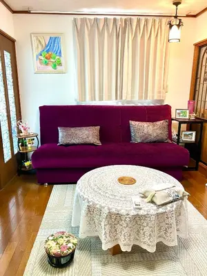 a living room with a purple couch and a table at Sakura Bloom Separate House in Tokyo
