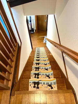 a stairway with a rug with animals on it at Sakura Bloom Separate House in Tokyo