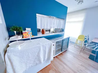 a room with a table and a blue wall at \u4e00\u68df\u8cb8\u3057\u5e83\u300570\u5e73\u7c73 \u8cb4\u9802\u5e9c\u90b8 \u897f\u65b0\u4e95 KICYO HOUSE No2 in Tokyo
