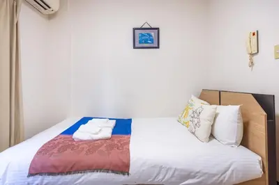 a bedroom with a bed with white sheets and pillows at residencematsubara in Tokyo