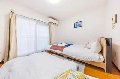 a bedroom with two beds and a window at residencematsubara in Tokyo