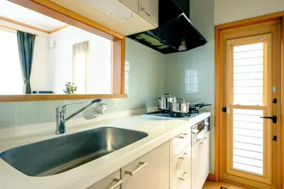 a kitchen with a stainless steel sink and a window at Haresora Mukojima Ikken House in Tokyo