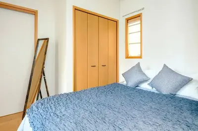 a bedroom with a blue bed and a wooden cabinet at Haresora Mukojima Ikken House in Tokyo