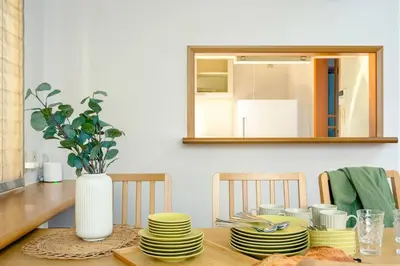 a dining room table with yellow plates and a mirror at Haresora Mukojima Ikken House in Tokyo