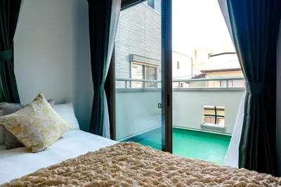 a bedroom with a bed and a large window at Haresora Mukojima Ikken House in Tokyo