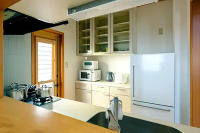 a kitchen with a white refrigerator and white cabinets at Haresora Mukojima Ikken House in Tokyo