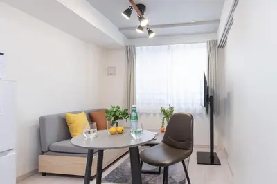 a living room with a table and a couch at \u30a6\u30a7\u30eb\u30b9\u30af\u30a8\u30a2\u30a4\u30ba\u30e0\u6c60\u888b\u30a6\u30a7\u30b9\u30c8 in Tokyo