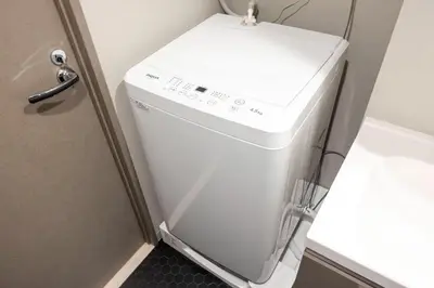 a white washer and dryer in a bathroom at \u30a6\u30a7\u30eb\u30b9\u30af\u30a8\u30a2\u30a4\u30ba\u30e0\u6c60\u888b\u30a6\u30a7\u30b9\u30c8 in Tokyo
