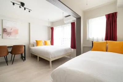 two beds in a room with a table and a desk at \u30a6\u30a7\u30eb\u30b9\u30af\u30a8\u30a2\u30a4\u30ba\u30e0\u6c60\u888b\u30a6\u30a7\u30b9\u30c8 in Tokyo
