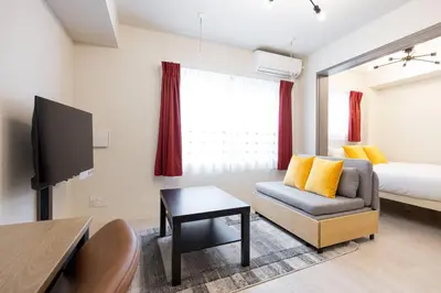 a living room with a couch and a bed at \u30a6\u30a7\u30eb\u30b9\u30af\u30a8\u30a2\u30a4\u30ba\u30e0\u6c60\u888b\u30a6\u30a7\u30b9\u30c8 in Tokyo