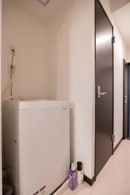 a white refrigerator in a room with a door at Asakusa Good Place Unmanned Hotel in Tokyo