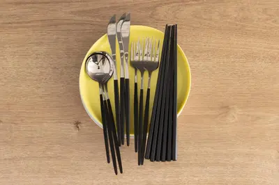 a yellow plate with forks and a spoon on a table at Asakusa Good Place Unmanned Hotel in Tokyo