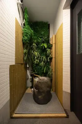 a room with a plant wall with a large vase at Asakusa Good Place Unmanned Hotel in Tokyo